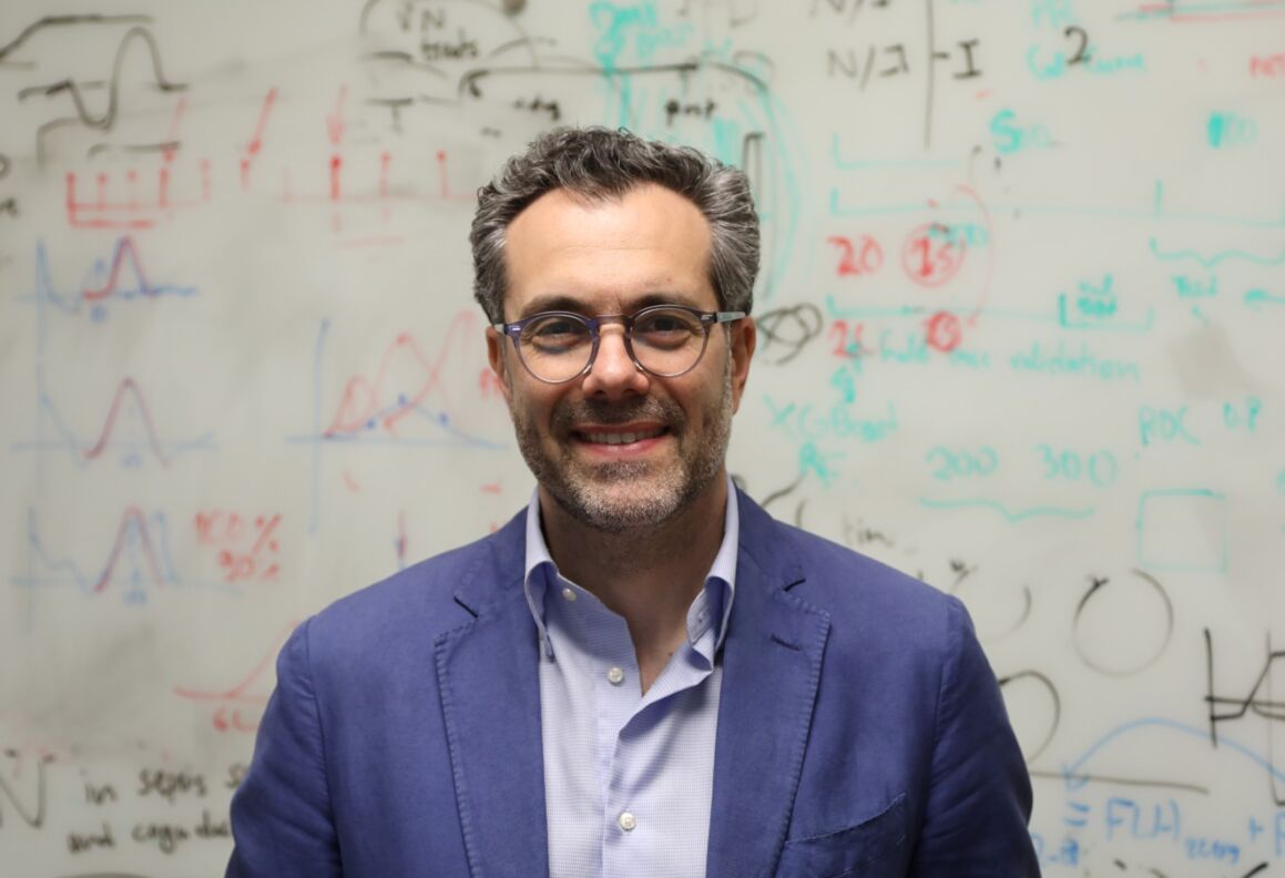 Theodoros Zanos at a whiteboard of equations